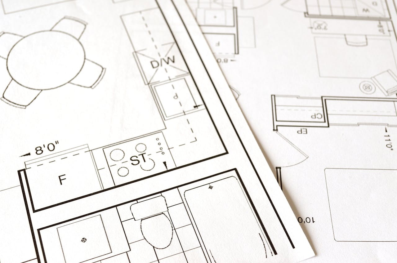 about-img Close-up view of an architectural floor plan on paper showcasing detailed room layouts and measurements.